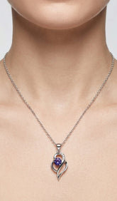Silver necklace with a heart-shaped pendant featuring a purple gemstone on a neutral background