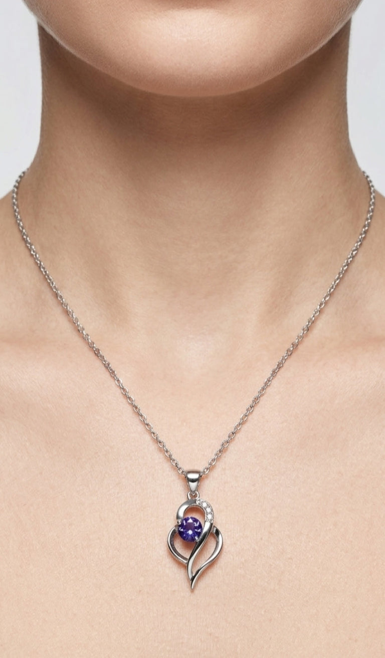 Silver necklace with a heart-shaped pendant featuring a purple gemstone on a neutral background