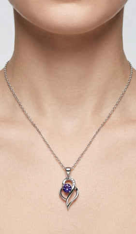 Silver necklace with a heart-shaped pendant featuring a purple gemstone on a neutral background