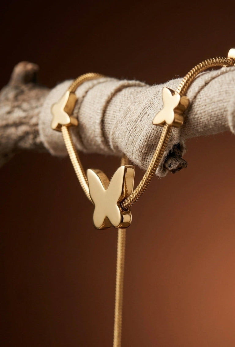 Gold butterfly bracelet on a textured surface with a brown background