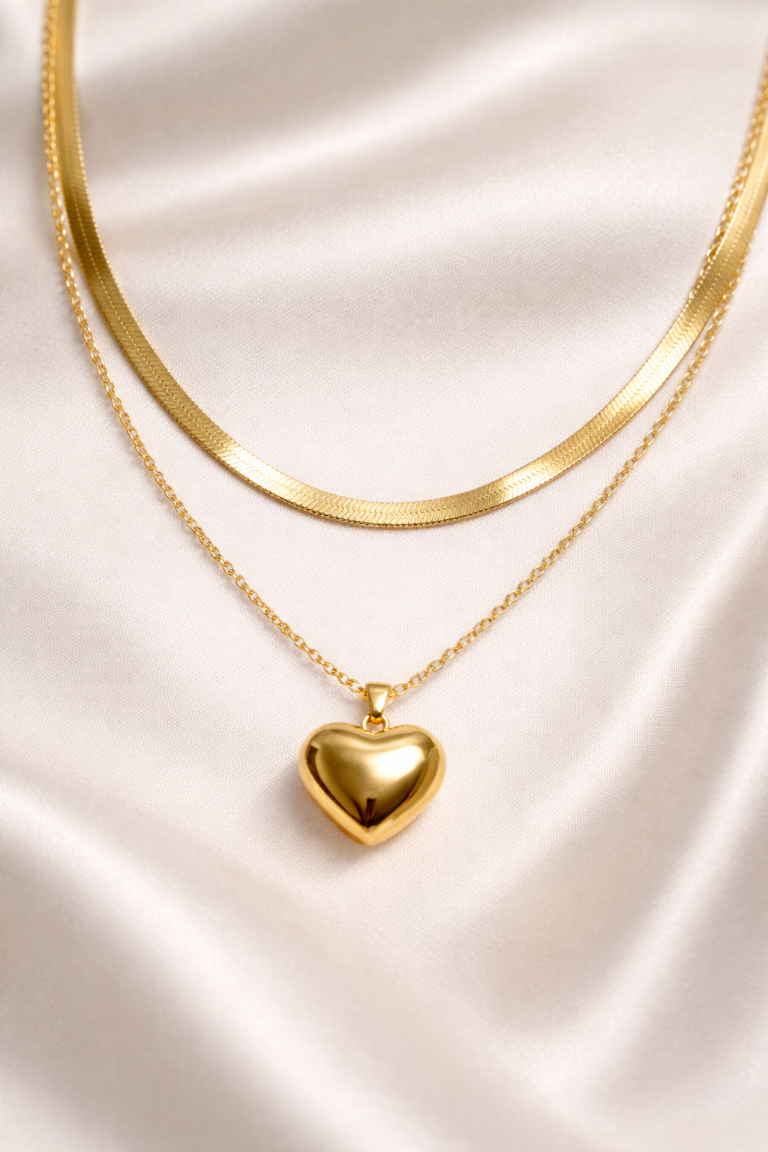 Gold heart-shaped pendant necklace on a satin surface