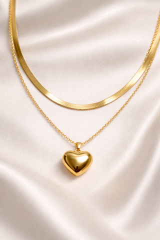 Gold heart-shaped pendant necklace on a satin surface