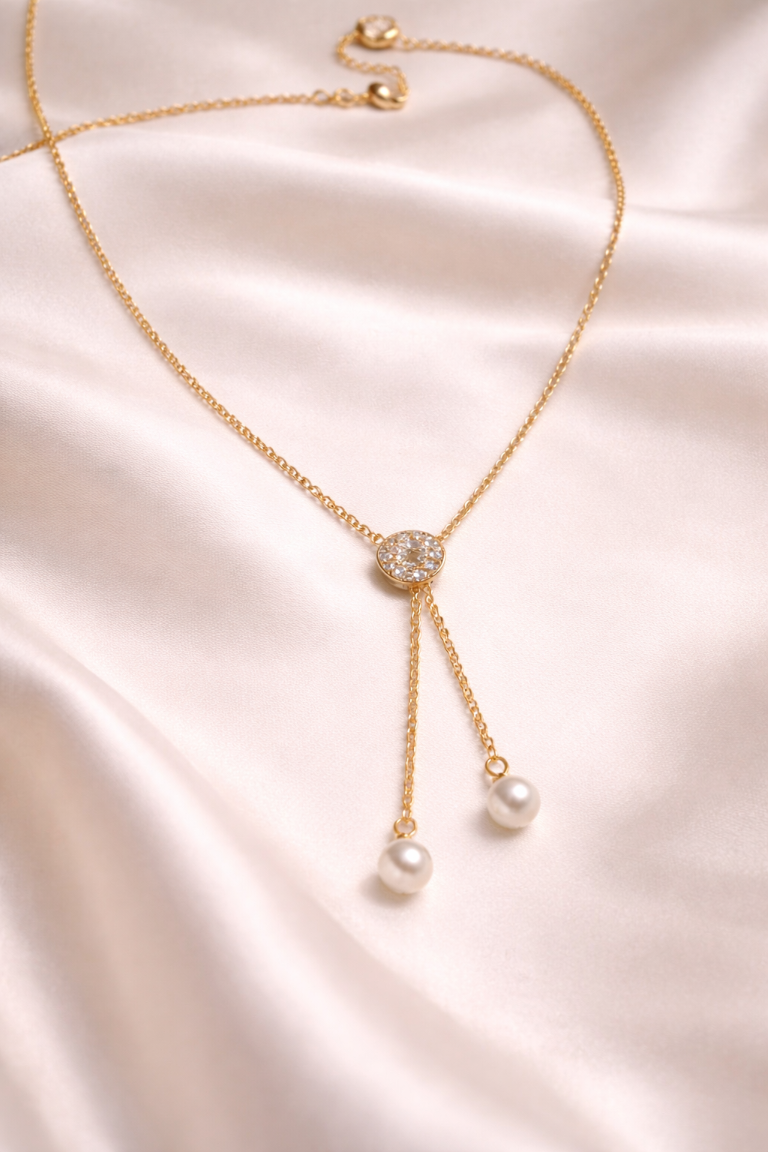 Gold necklace with pearl pendants on a satin surface