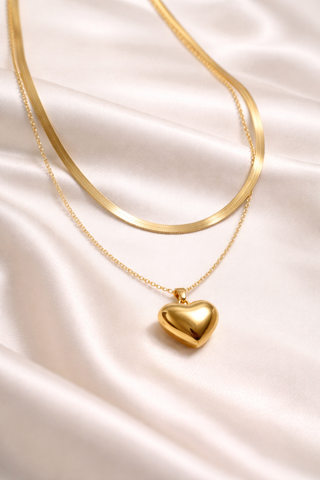 Gold heart-shaped pendant necklace on a soft fabric background